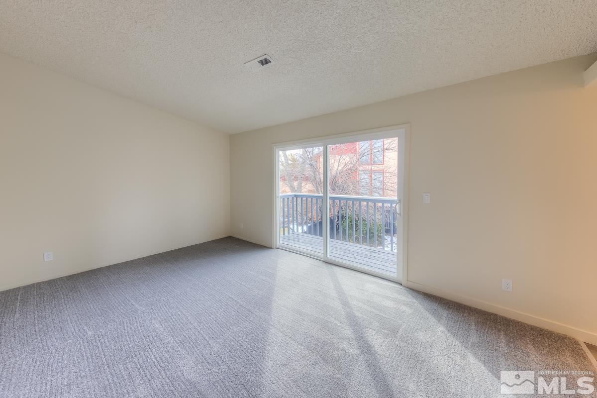 7196 Indigo Circle Reno, NV 89506 - Photo 4 of 33 an empty room with wooden floor and windows
