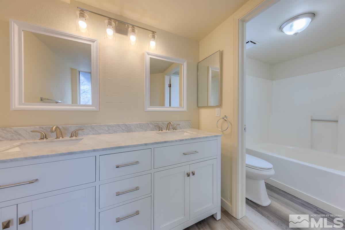 7196 Indigo Circle Reno, NV 89506 - Photo 7 of 33 a bathroom with a granite countertop sink mirror and toilet