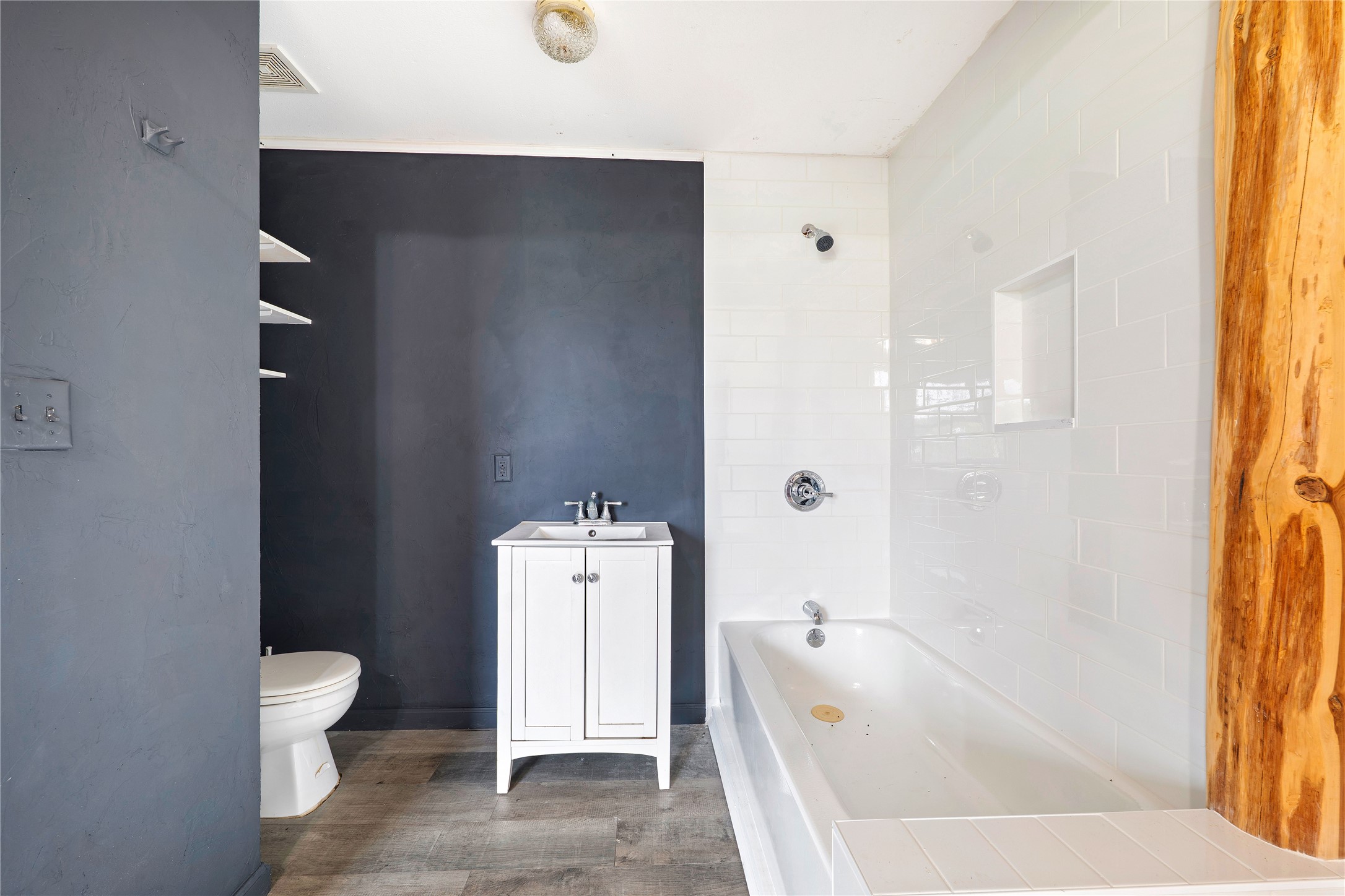 358 Easley Road Smithville, TX 78957 - Photo 18 of 33 Bathroom vanity featuring a vessel sink, storage cabinetry, wall-mounted mirror, and convenient separation from the bathing area.