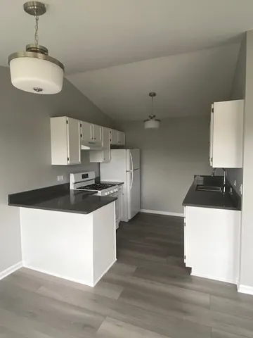 a kitchen with stainless steel appliances a sink a stove and a wooden floors
