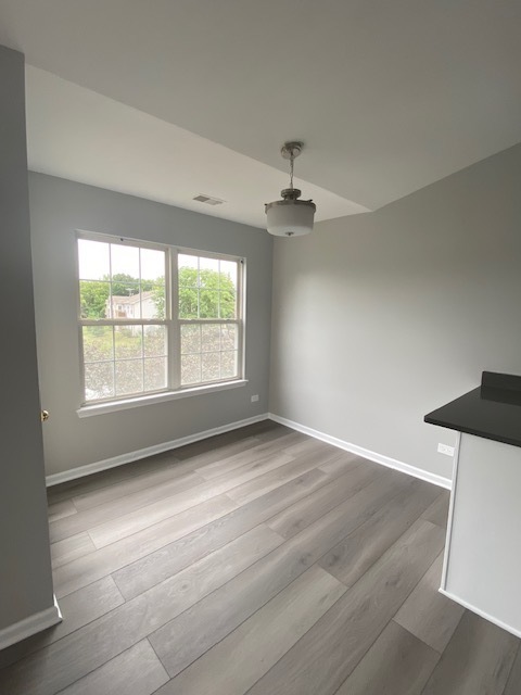 1127 North Red Oak Circle, Unit 4 Round Lake Beach, IL 60073 - Photo 22 of 31 wooden floor in an empty room with a window