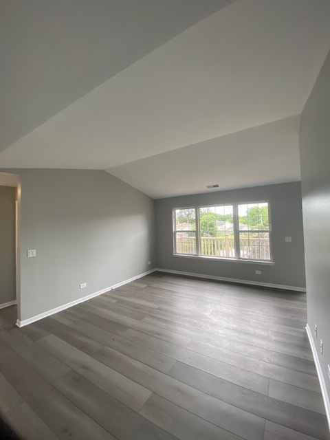 1127 North Red Oak Circle, Unit 4 Round Lake Beach, IL 60073 - Photo 25 of 31 an empty room with wooden floor and windows