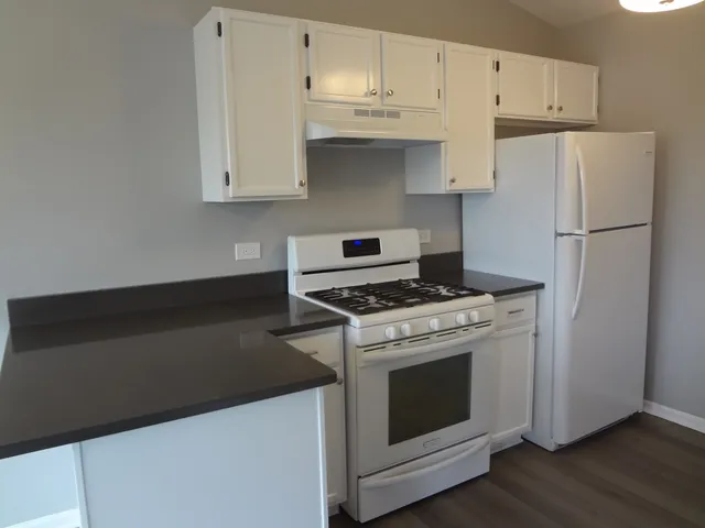 a kitchen with white cabinets and white appliances