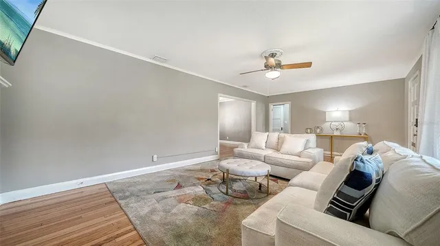 a living room with furniture and a ceiling fan