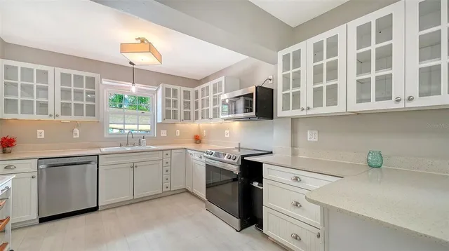 a kitchen with stainless steel appliances granite countertop a sink and dishwasher a stove top oven with wooden floor