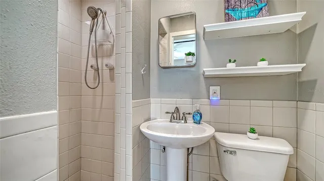 a bathroom with a sink a toilet and shower