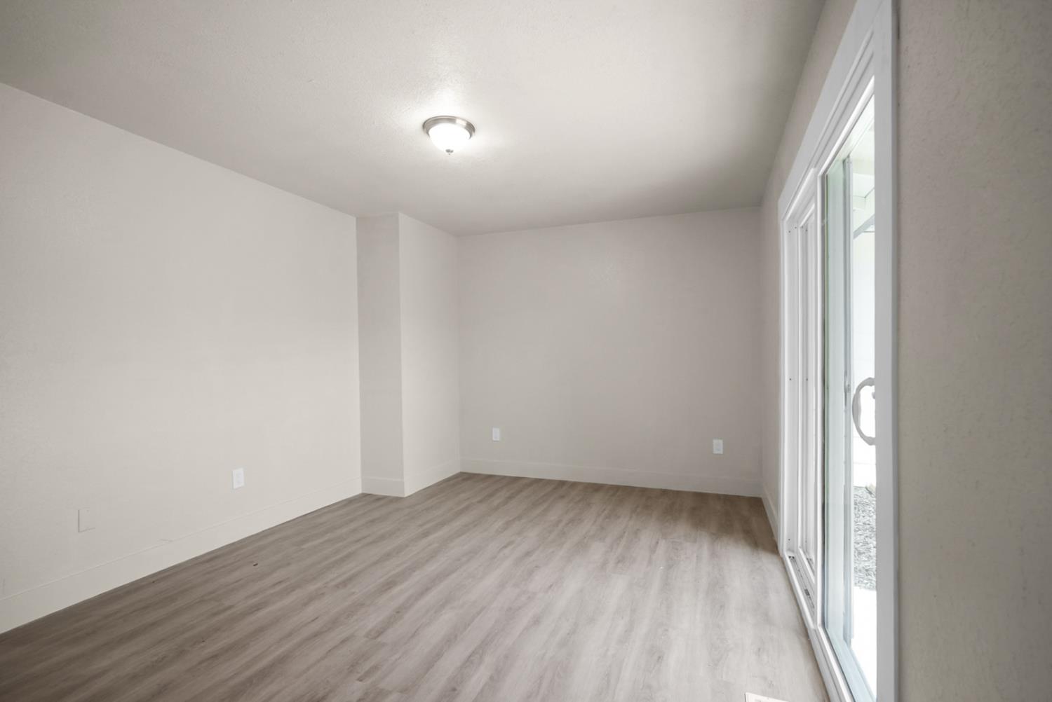 2832 Fowler Road Ceres, CA 95307 - Photo 13 of 28 an empty room with wooden floor and windows