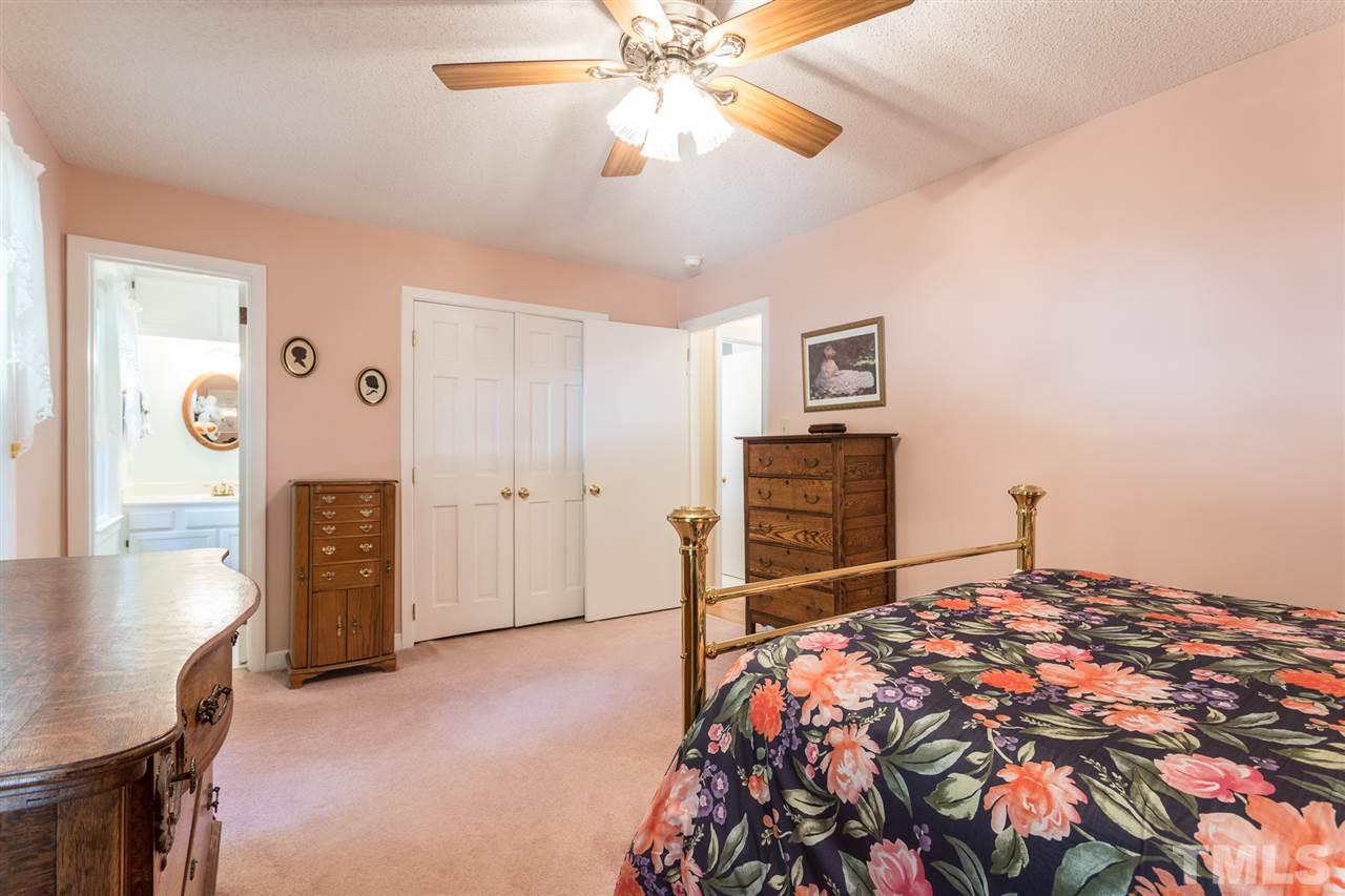 1430 Ridge Road Raleigh, NC 27607 - Photo 22 of 30 a bedroom with a bed and a chandelier