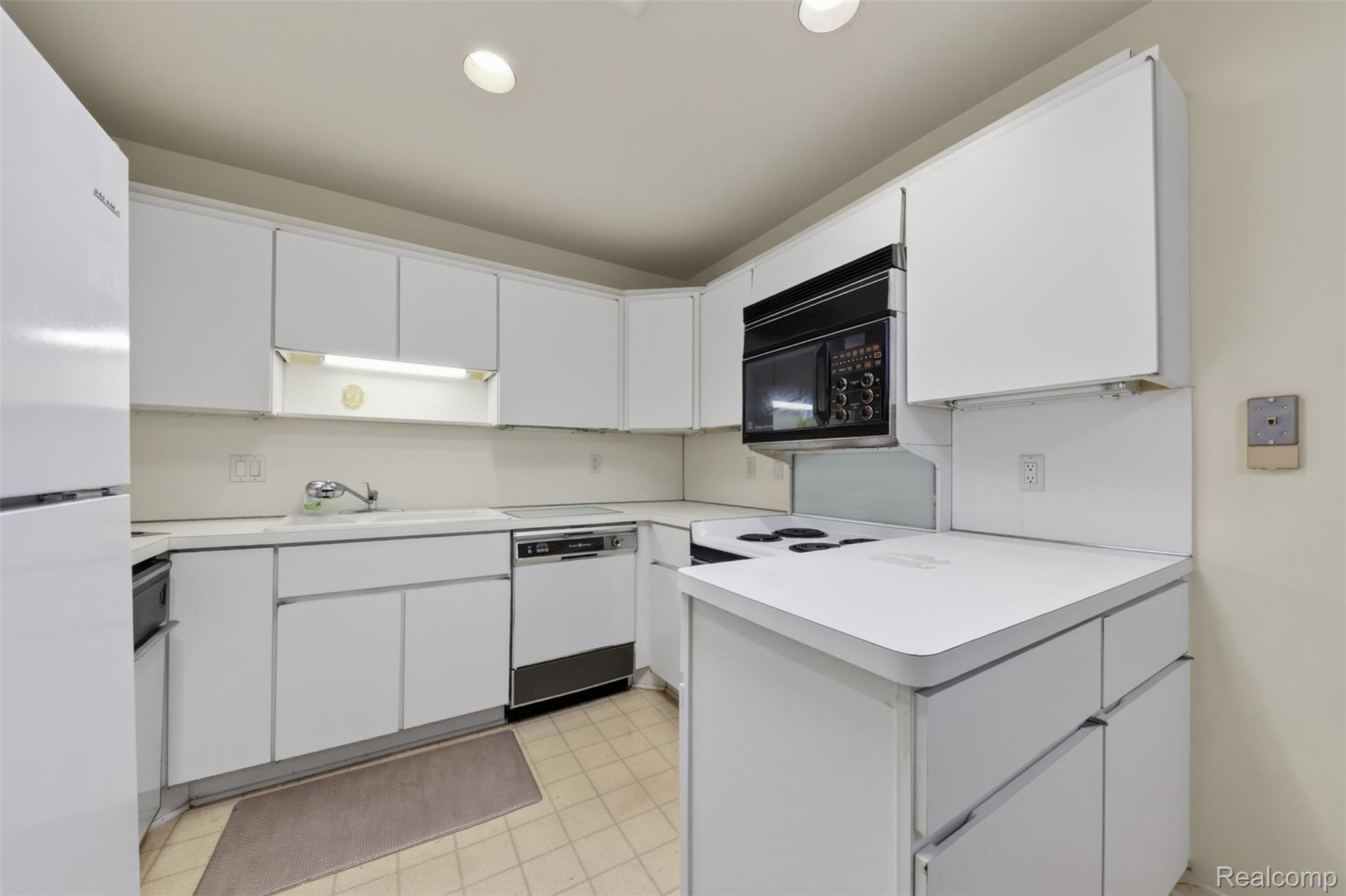 31915 West 14 Mile Road Farmington, MI 48334 - Photo 16 of 47 White cabinetry, integrated microwave, built-in dishwasher, white countertops, and recessed lighting