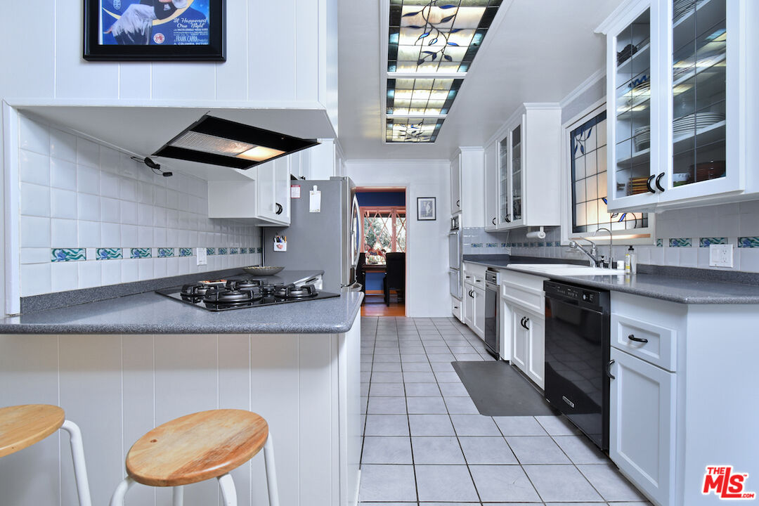 3833 Woodcliff Road Sherman Oaks, CA 91403 - Photo 15 of 52 a kitchen with stainless steel appliances a stove a sink and a refrigerator