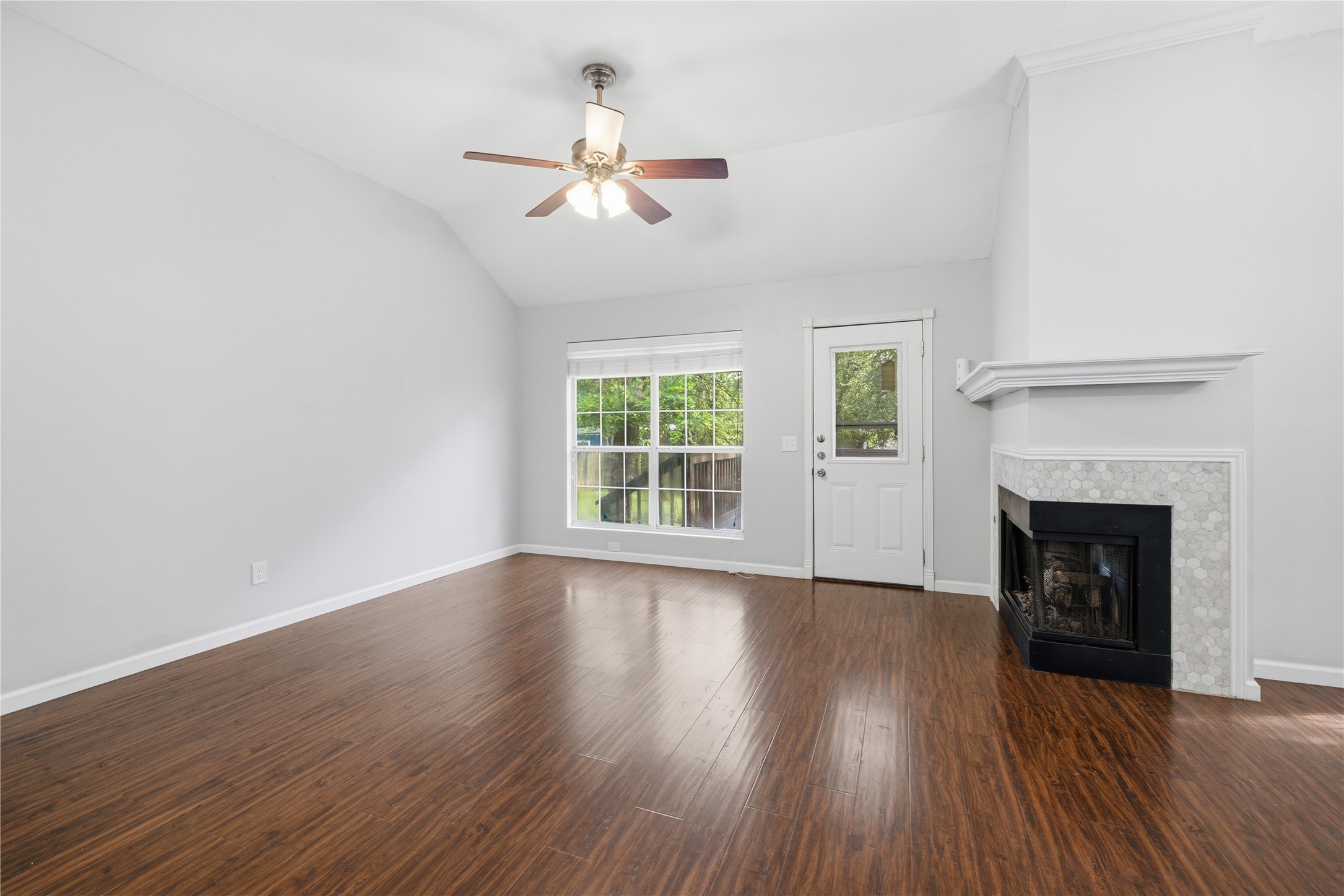2922 Wickersham Lane Austin, TX 78741 - Photo 22 of 26 a view of an empty room with wooden floor fireplace and a window
