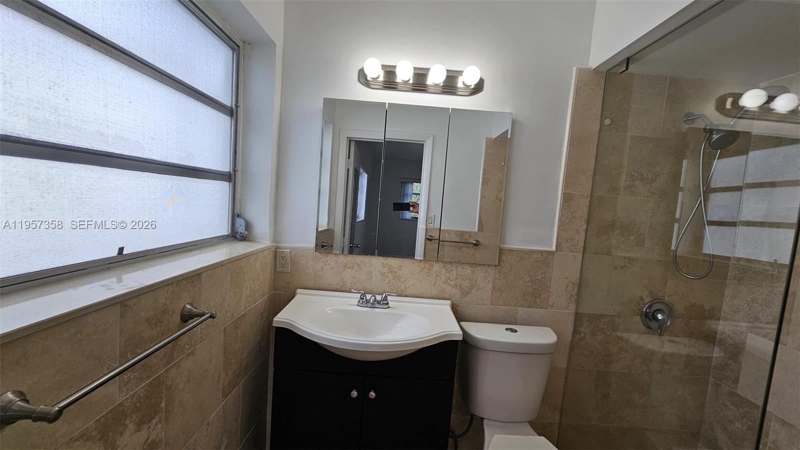 9348-9356 Byron Avenue Surfside, FL 33154 - Photo 25 of 31 a bathroom with a sink and a mirror