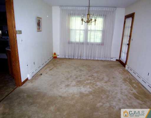 13 Ramsey Road Edison, NJ 08820 - Photo 3 of 8 an empty room with a windows and chandelier