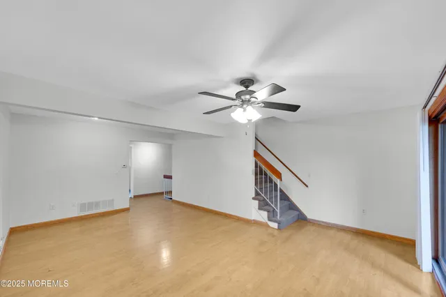 a view of an empty room with window and cabinet