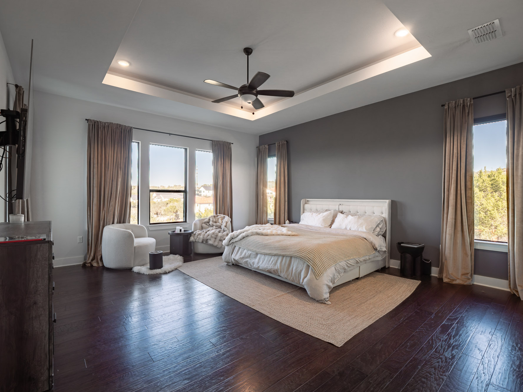 14900 Copper Ridge Lane Austin, TX 78734 - Photo 18 of 39 Bedroom featuring dark wood-style flooring, a tray ceiling, and a ceiling fan