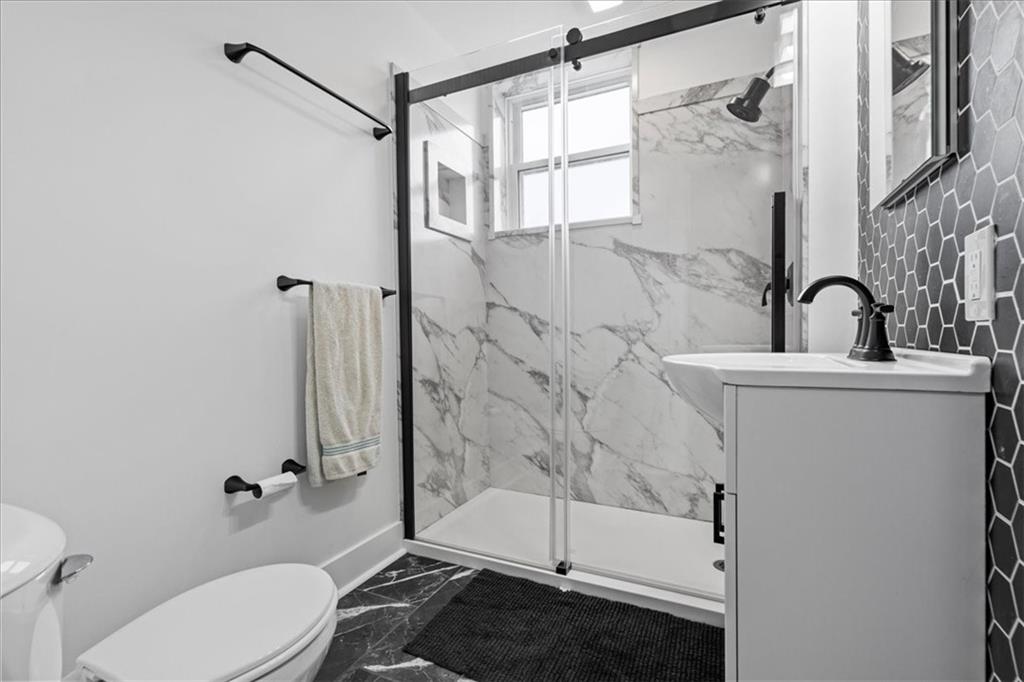 4731 Butler Street Pittsburgh, PA 15201 - Photo 29 of 50 a bathroom with a shower a toilet and sink