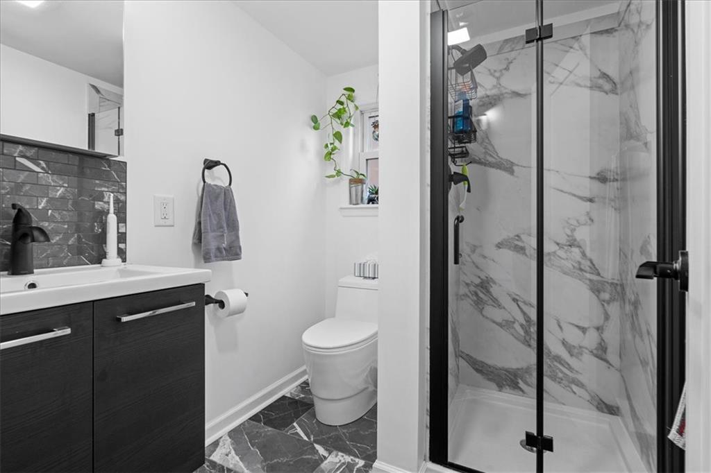 4731 Butler Street Pittsburgh, PA 15201 - Photo 37 of 50 a bathroom with a granite countertop sink toilet and shower