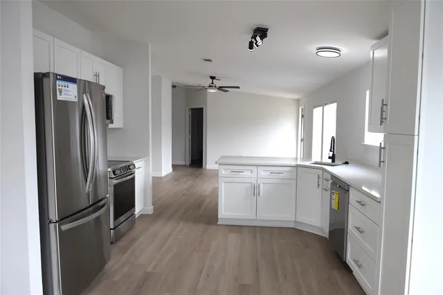 a kitchen with a refrigerator sink and cabinets