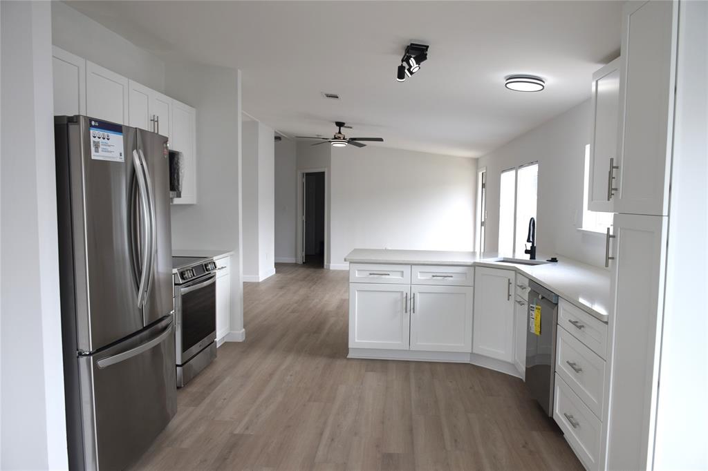 a kitchen with a refrigerator sink and cabinets