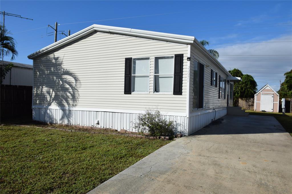 22971 Tradewind Road Boca Raton, FL 33428 - Photo 2 of 13 a front view of a house with a yard