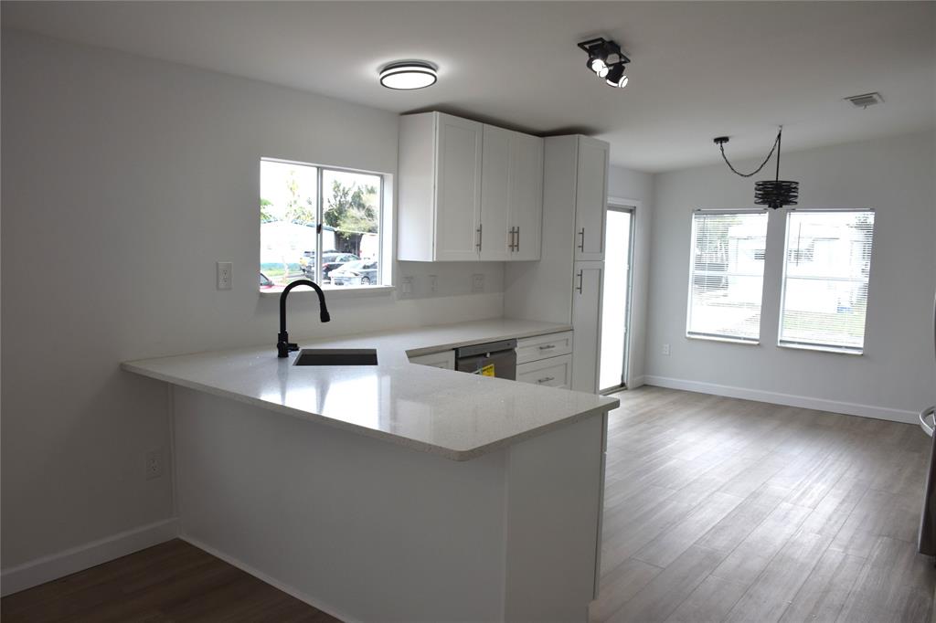 22971 Tradewind Road Boca Raton, FL 33428 - Photo 5 of 13 a kitchen with stainless steel appliances a sink a window and wooden floor