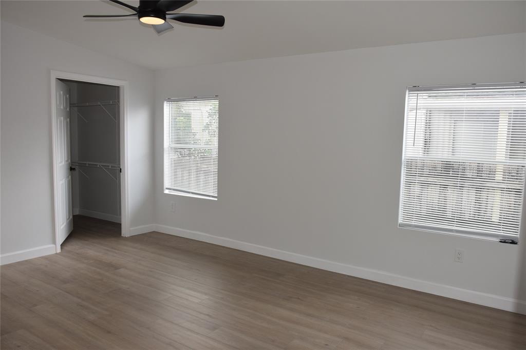 22971 Tradewind Road Boca Raton, FL 33428 - Photo 8 of 13 an empty room with wooden floor fan and windows