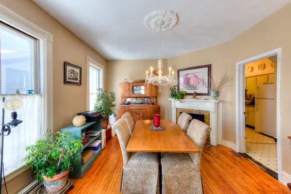 a view of a dining room with furniture a chandelier and wooden floor
