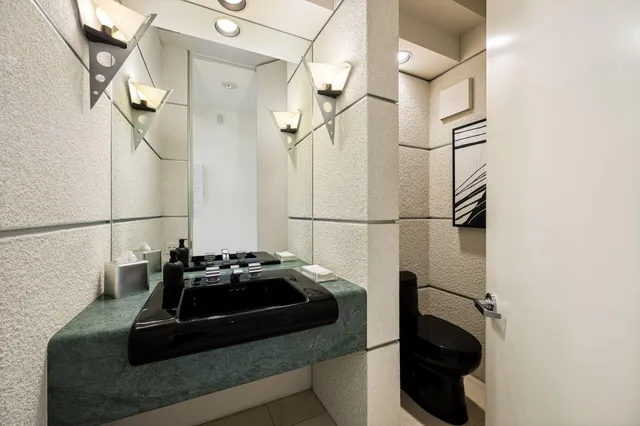 a spacious bedroom with a bed a couch and a large window