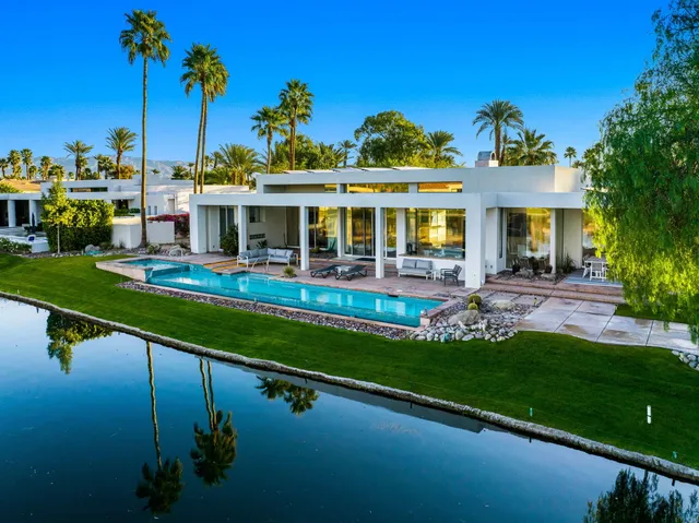 a front view of a house with swimming pool having outdoor seating