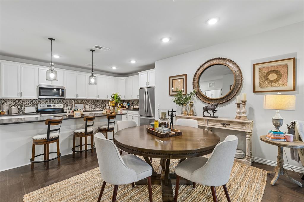 651 Watters Road, Unit 7204 Allen, TX 75013 - Photo 9 of 40 a kitchen with a dining table chairs stove and cabinets