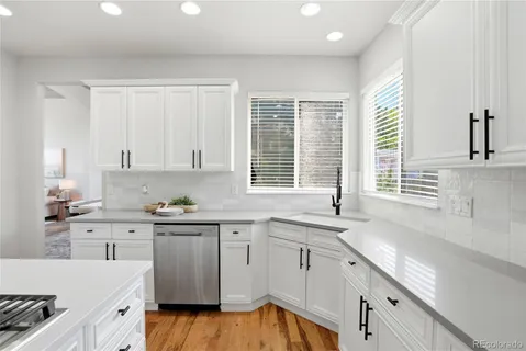 a kitchen with granite countertop white cabinets and white appliances
