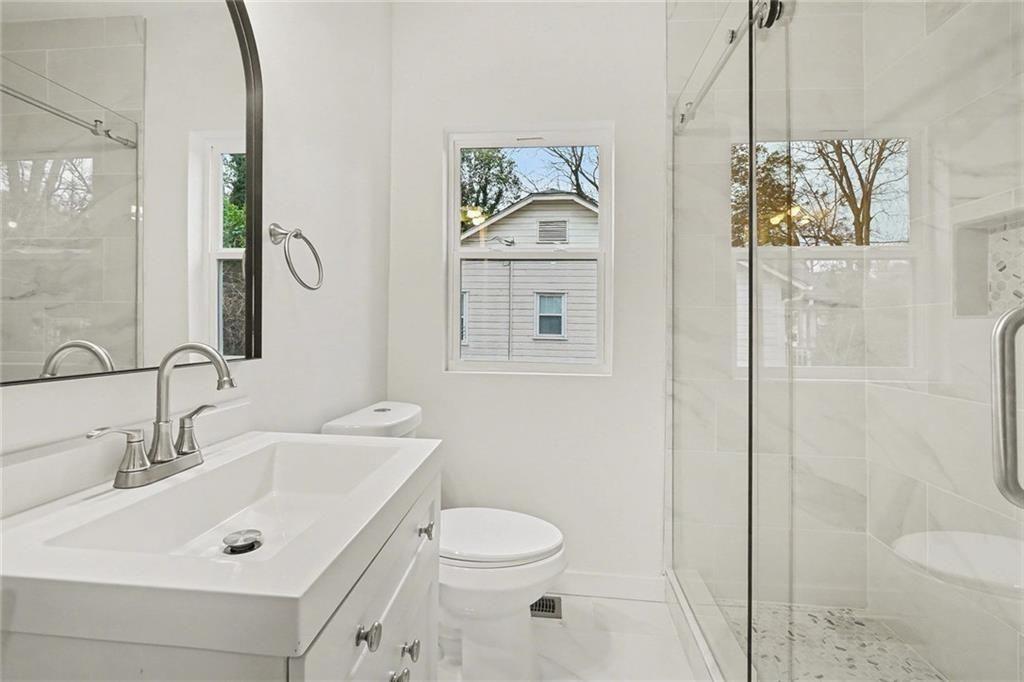 1684 Kenmore Street Southwest Atlanta, GA 30311 - Photo 11 of 30 a bathroom with a sink a toilet and shower