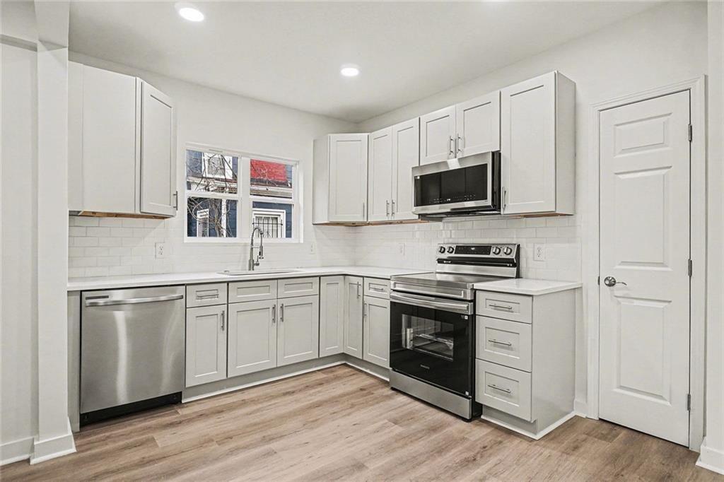 1684 Kenmore Street Southwest Atlanta, GA 30311 - Photo 16 of 30 a kitchen with stainless steel appliances granite countertop a stove and a refrigerator