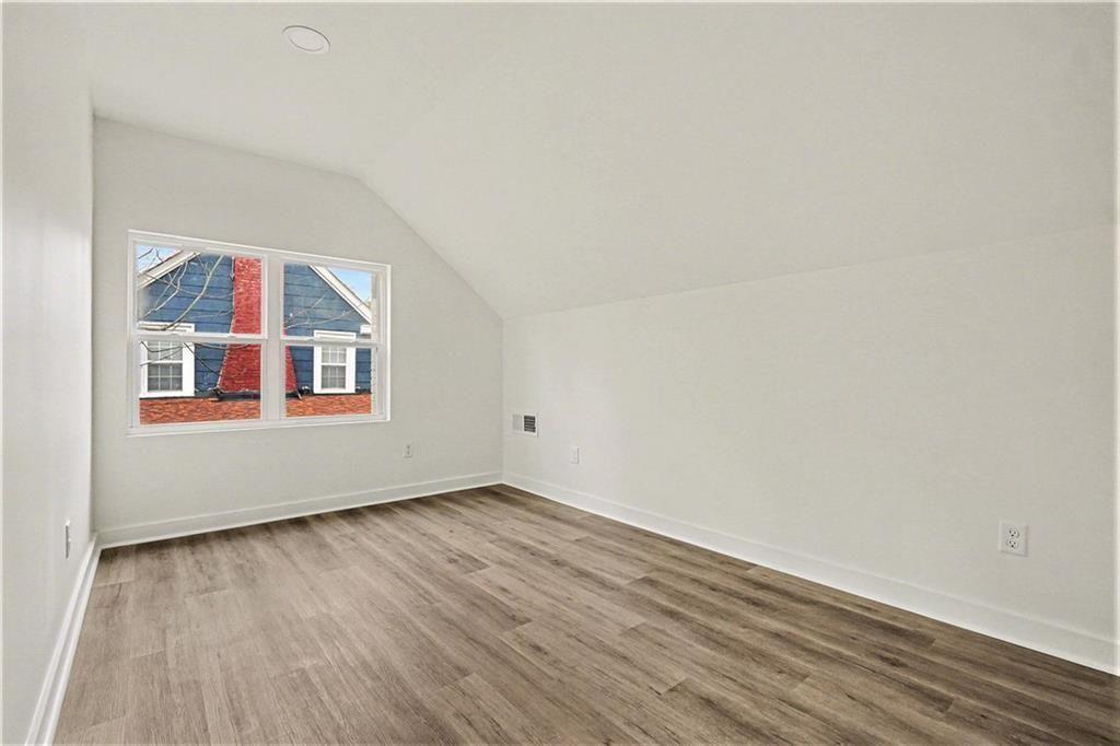 1684 Kenmore Street Southwest Atlanta, GA 30311 - Photo 20 of 30 an empty room with wooden floor and windows