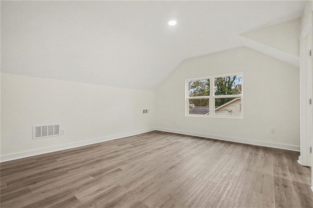 1684 Kenmore Street Southwest Atlanta, GA 30311 - Photo 23 of 30 an empty room with wooden floor and windows