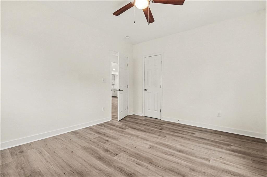 1684 Kenmore Street Southwest Atlanta, GA 30311 - Photo 10 of 30 an empty room with ceiling fan and wooden floor
