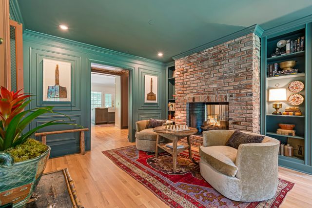 a hallway with a view of living room and wooden floor