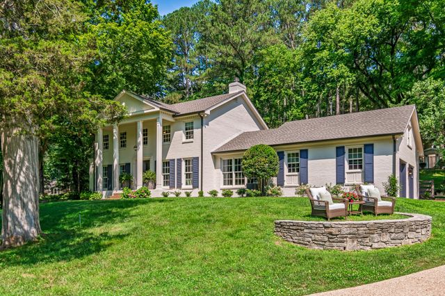 a living room with fireplace furniture and a large window