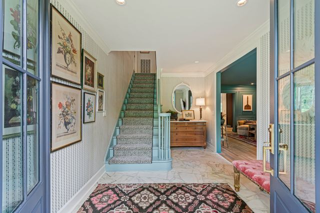 a view of a hallway with wooden floor and a mirror