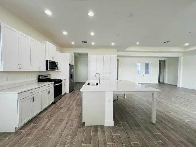 a large kitchen with stainless steel appliances lots of counter top space and cabinets