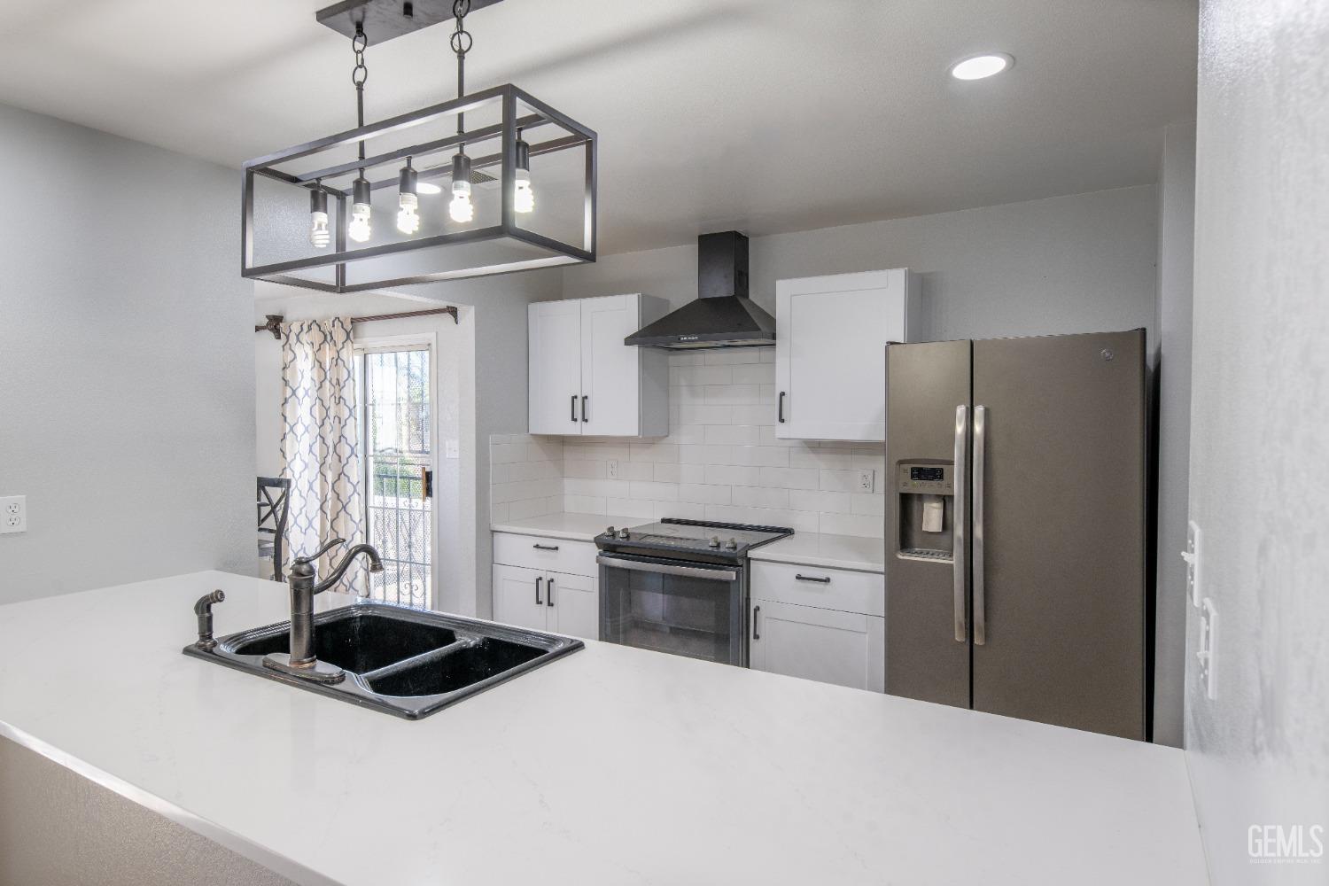 a kitchen with stainless steel appliances a sink a refrigerator a stove a microwave and cabinets