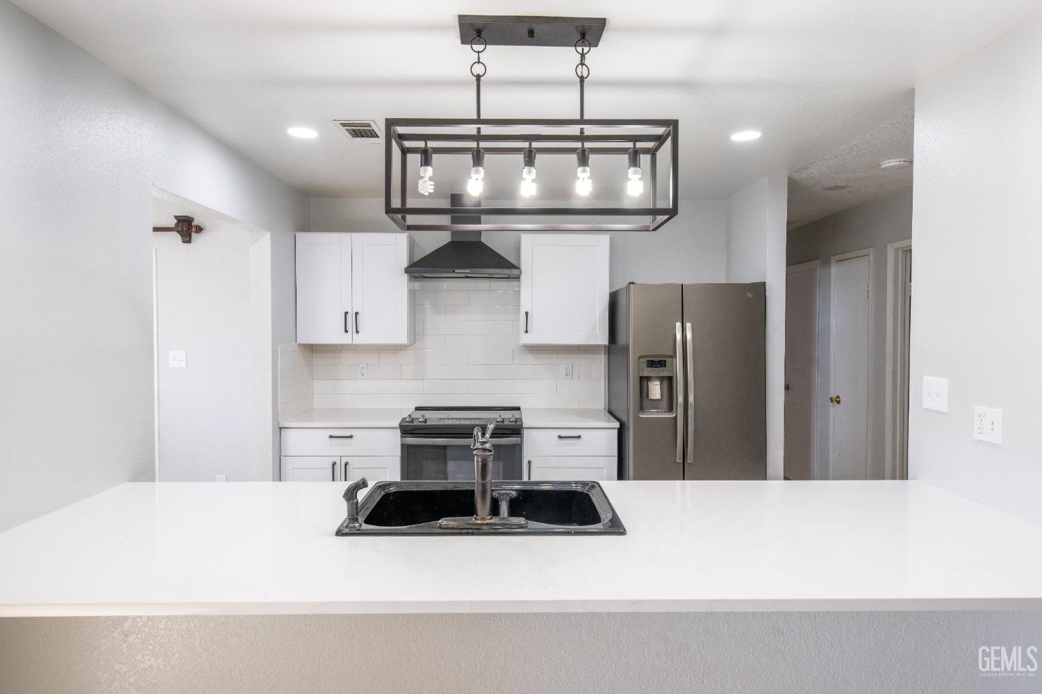 Undisclosed Address Delano, CA 93215 - Photo 5 of 19 a kitchen with stainless steel appliances a microwave a stove and white cabinets