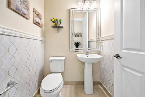 a bathroom with a sink a toilet and mirror