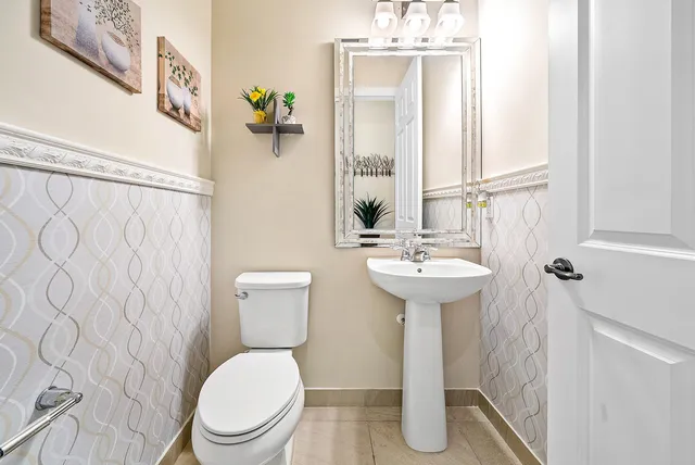 a bathroom with a sink a toilet and mirror