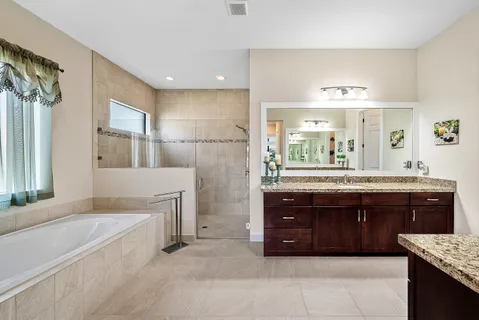 a spacious bathroom with a granite countertop tub sink and mirror