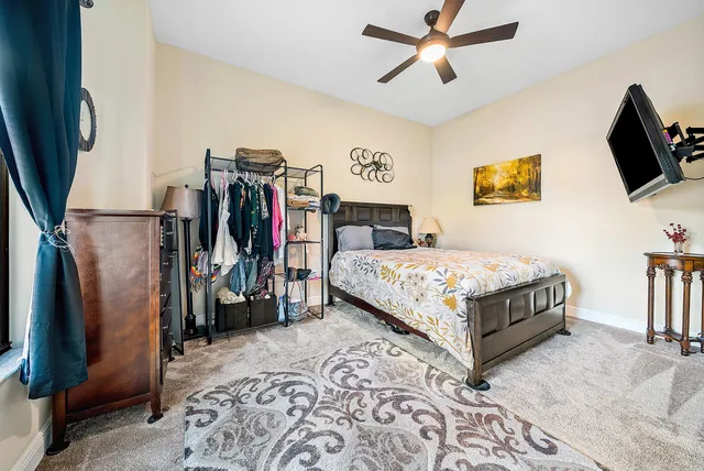 a bedroom with bed and a flat tv screen on dresser