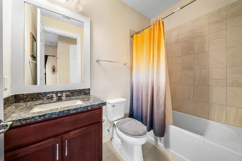 a bathroom with a granite countertop sink toilet and shower