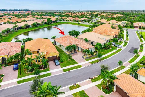 an aerial view of a house with a garden and lake view