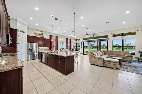 a large living room with stainless steel appliances granite countertop a large kitchen counter top a stove and a sink