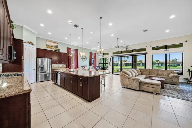 a large living room with stainless steel appliances granite countertop a large kitchen counter top a stove and a sink